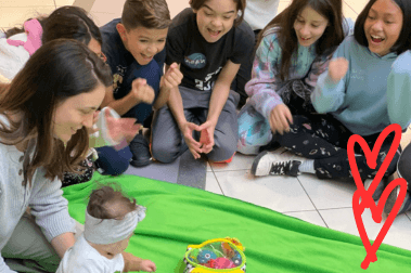 Children gathered around the Green blanket